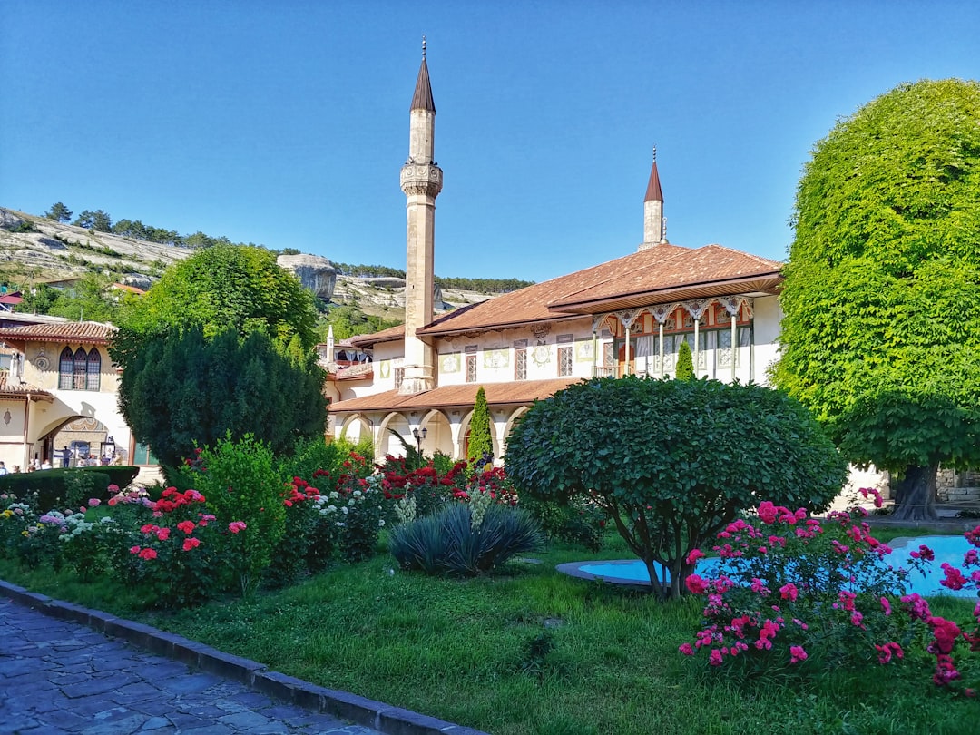 a large building with a clock tower in the middle of a garden