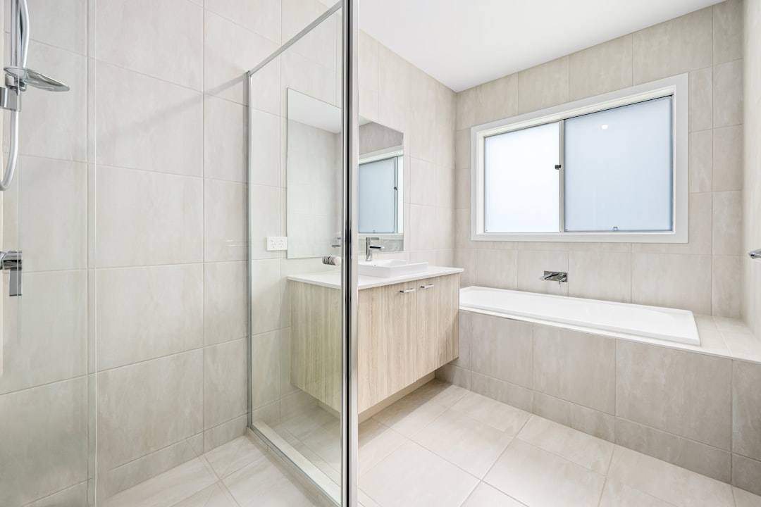 A white bathroom with a glass shower door